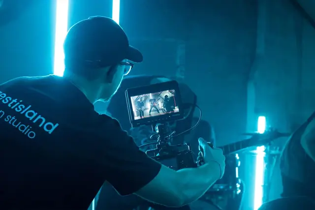 Pascal Sorgatz an der Kamera beim Musikvideo-Dreh im Studio mit blauem Licht